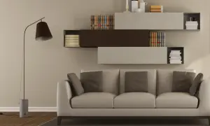 Nowoczesny salon z sofą w kolorze beżowym i kremowym, półkami z książkami i lampą.